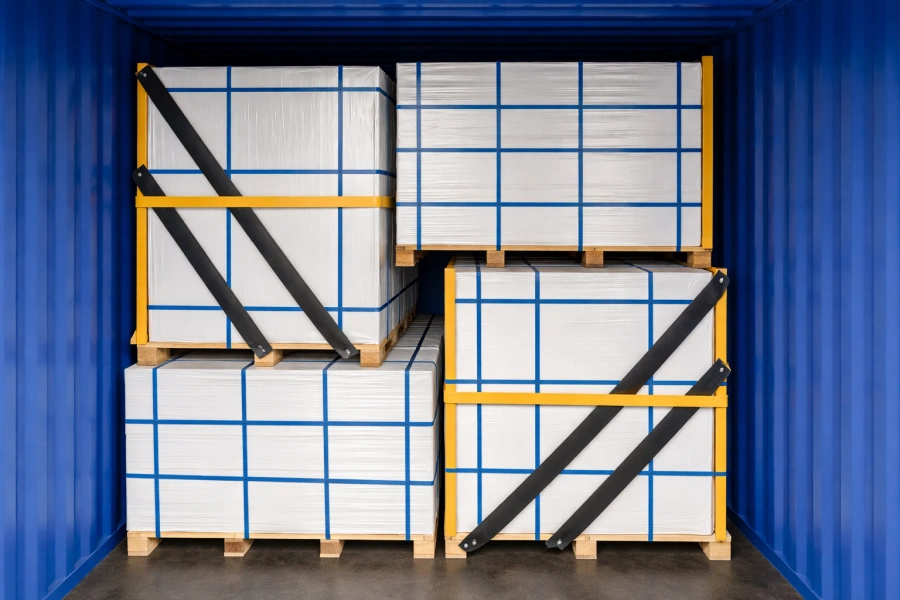 Horizontal and vertical pallets loaded with magnesium oxide boards are arranged alternately inside the container.
